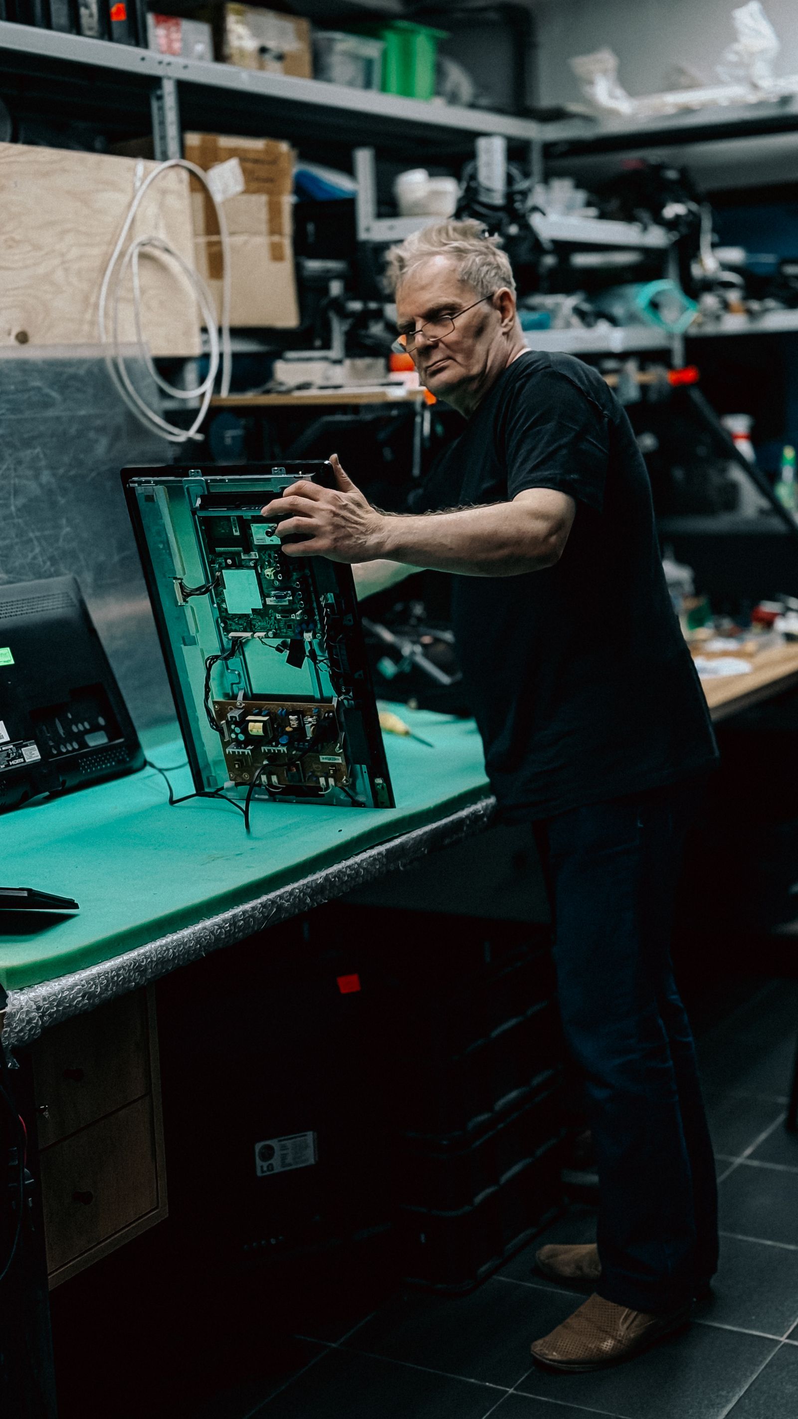 Technician inspecting a TV circuit board ahead of panel replacement — TVCare Mumbai service in Mira Road